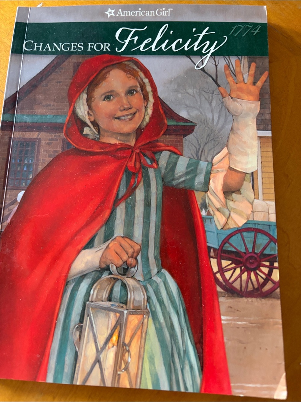 American Girl Book Featuring Girl in Red Cape and Green Striped Dress